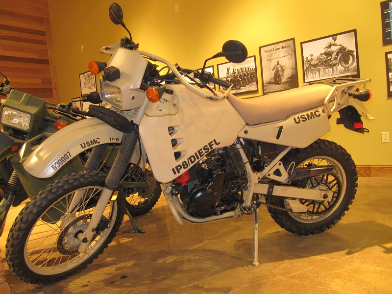 Kawasaki Hayes DT (KLR 1030 M-1) Código Militar USA. Código Civil: KLR 650 Diesel. The M1030 is a lightweight, rugged, commercial, cross-country motorcycle, based on the Kawasaki KLR 650, modified for military use. It provides an alternate means of transporting messages, documents, and light cargo between units. The M1030 may also be used to transport forward observers, military police, and reconnaissance personnel. The size and construction of the M1030 makes it highly mobile on all roads and cross-country terrain.