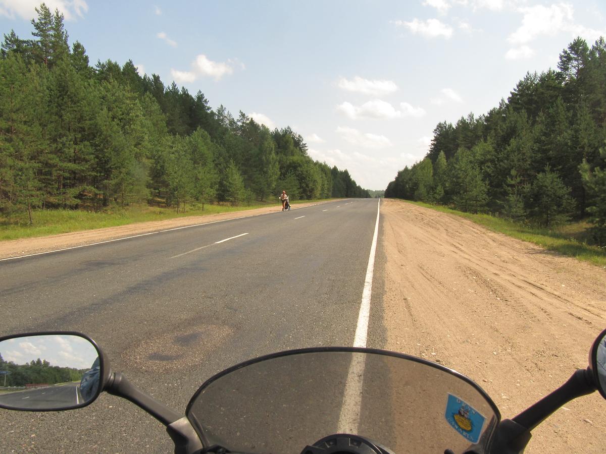 Un hombre y un carrito en la carretera en algún lugar a unos 200 km al E de Zilupe (Letonia).