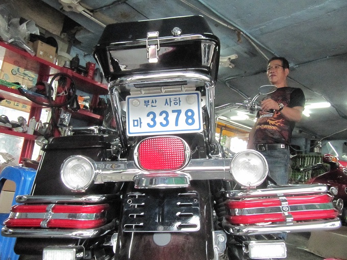 Mi hermano Yon Chei Kiu reparando una moto en Busán, Korea del Sur.